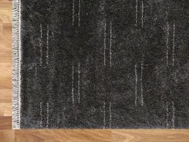 Close up of Enrica Pattern Area Rug in Charcoal in a modern living room