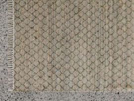Close up of Myra Jute Pattern Rug in Moss Grey in a modern living room