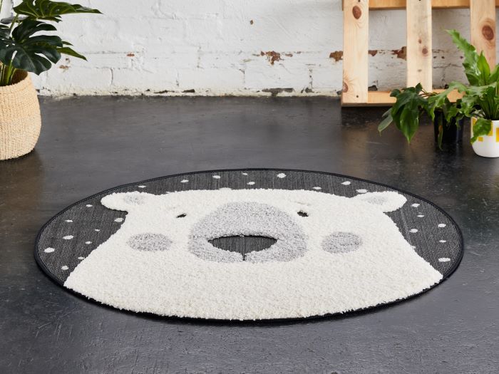 photo of arlo polar bear round kids rug on floor with palettes and plants