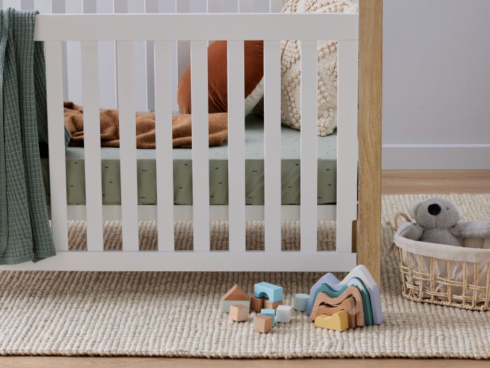 Close up photo of modern nursery containing Aster 2PCE Hardwood Convertible Baby Cot and Changing Table Set in White and Natural