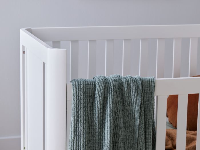 Close up Photo of modern nursery furniture containing  Aster Hardwood Baby Cot in White
