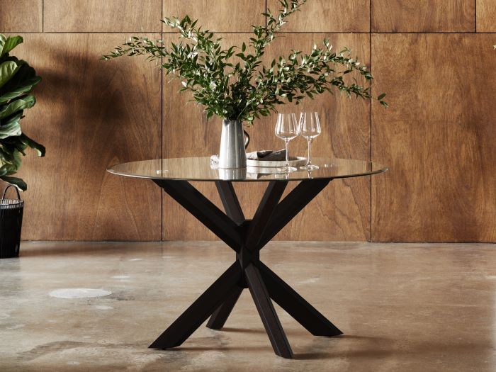 Modern dining room containing Bella round glass top dining table with black hardwood frame