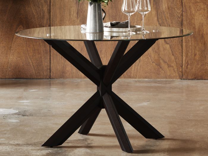 Close up of modern dining room containing Bella round glass top dining table with black hardwood frame