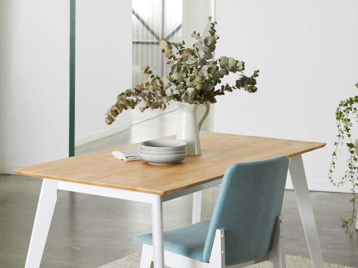 close up photo of finn hardwood dining table in natural with finn hardwood dining chair in aqua