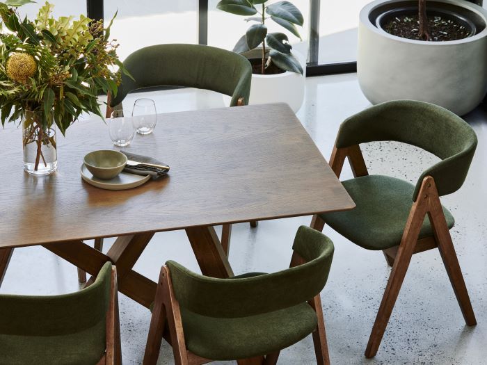 photo of Gaudi walnut dining table with Gaudi hardwood dining chair in green fabric