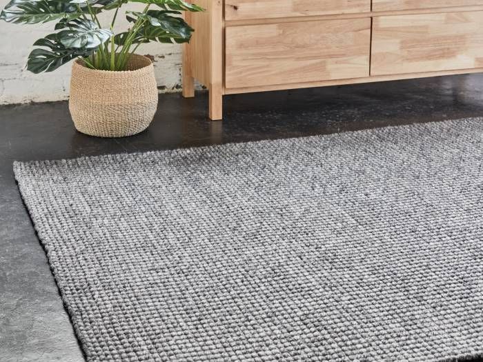 close up of room with modern furniture containing giza indoor wool area rug in charcoal