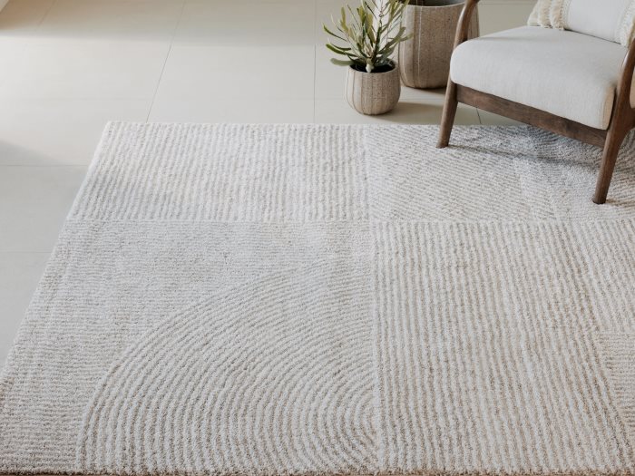 Close up photo of Tyric Pattern Area Rug in Beige in a modern living room
